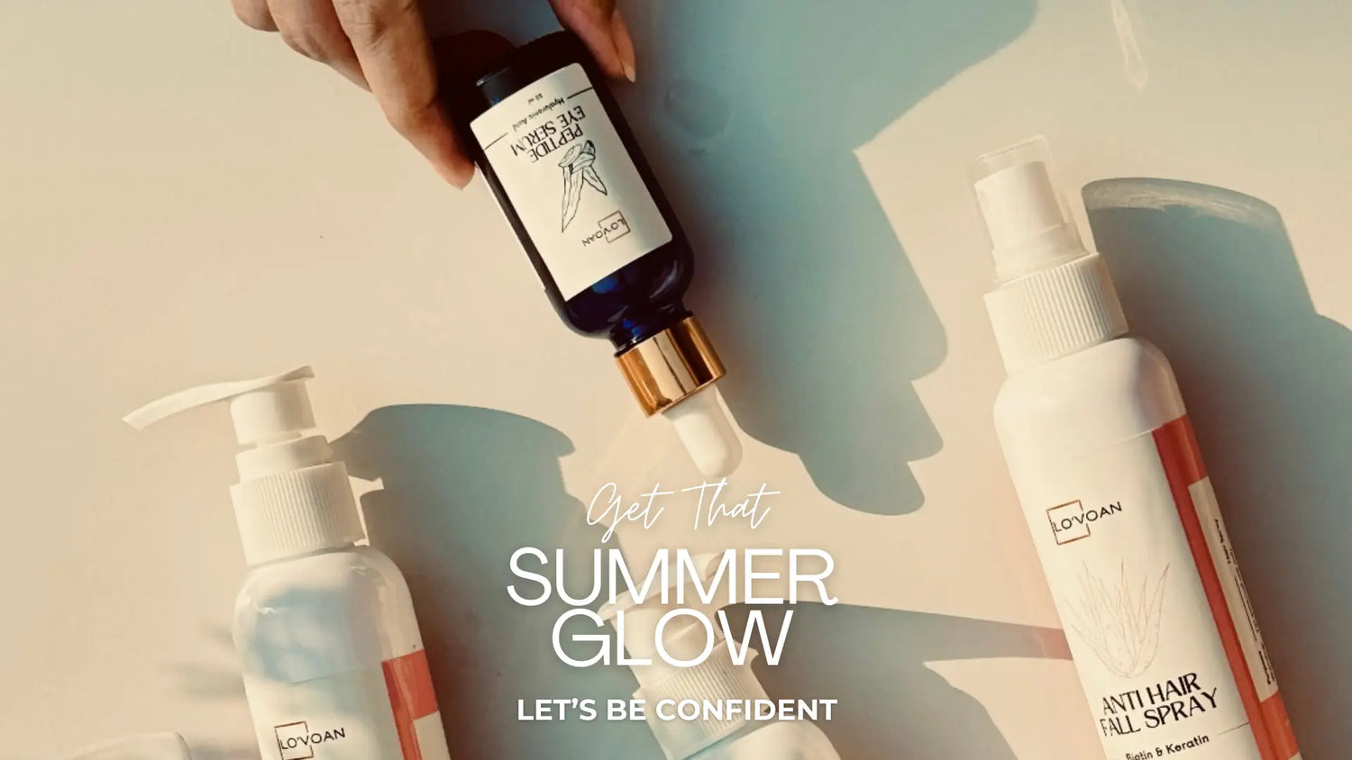 Lo'voan four skincare products, Moisturizing Lotion, Tea Tree Cleanser, Anti Hair Fall Spray and Peptide Eye Serum, with text "Get That SUMMER GLOW" on a shadow-patterned surface.