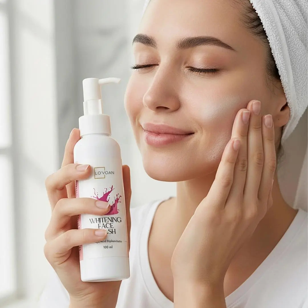 LOVOAN Whitening Facewash bottle held by a smiling woman gently applying the product to her cheek — highlighting a clean, bright, glowing skin look, soft natural lighting.